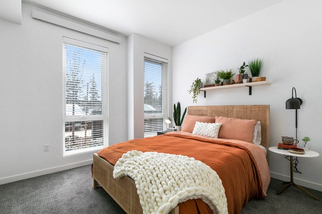 a bedroom with a bed and two windows