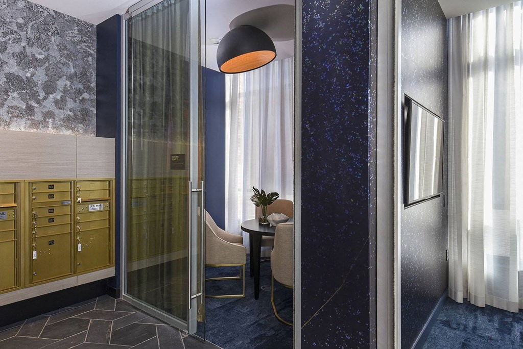 a small room with a shower and a table with a chair