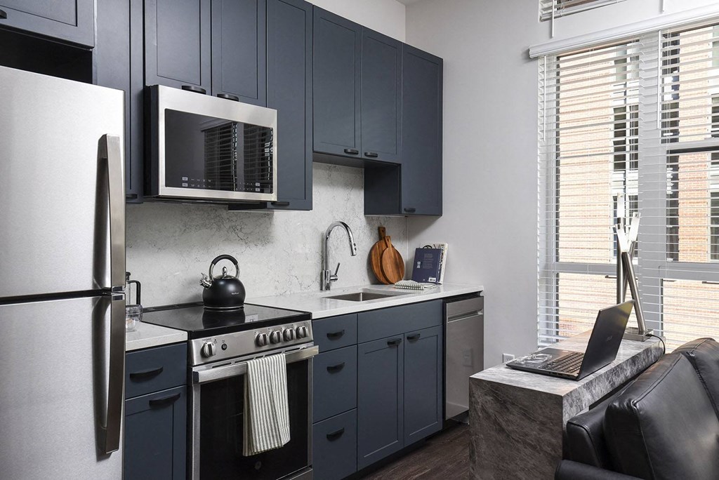 a kitchen with blue cabinets and a sink and a microwave