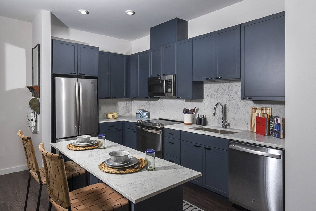 a kitchen with stainless steel appliances and blue cabinets