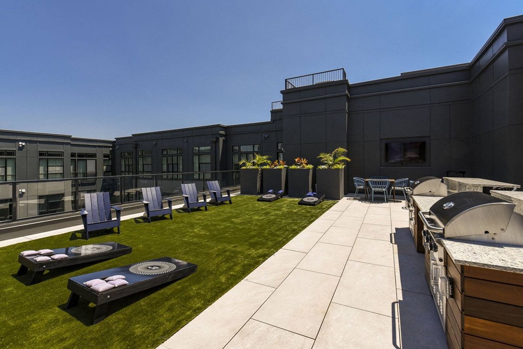 a patio with lounge chairs and tables on a lawn