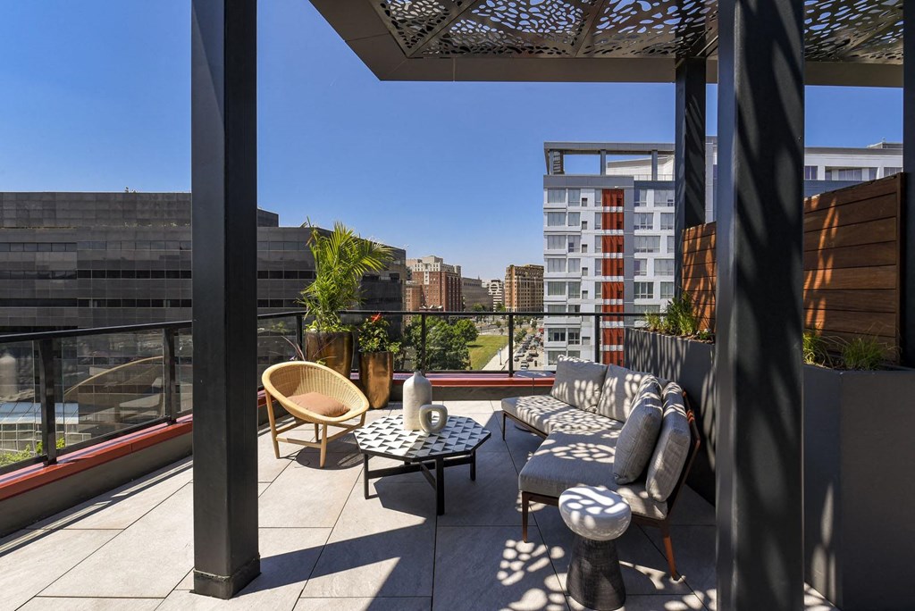 a terrace with a couch and chairs on a roof