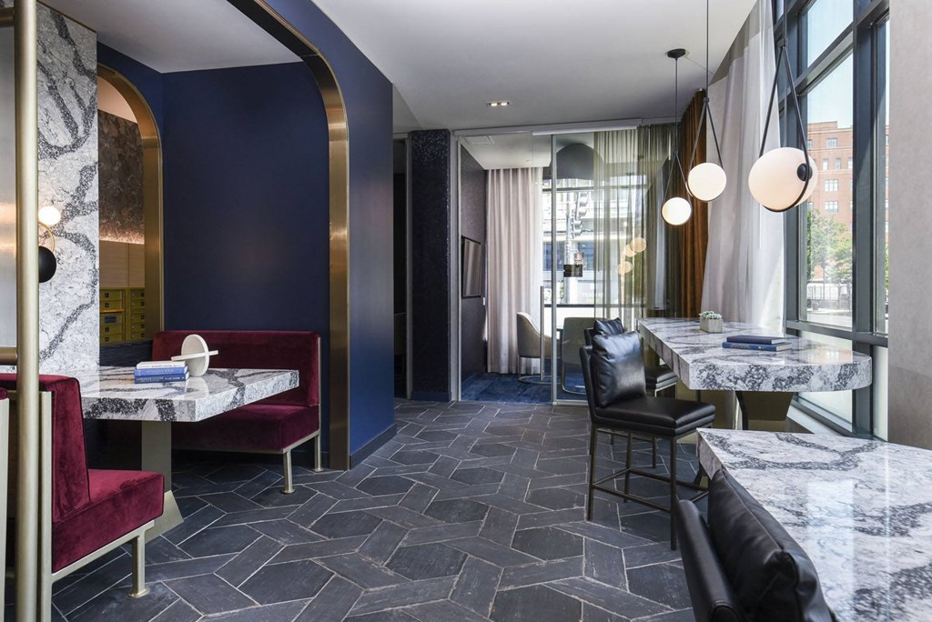 a living room and dining room with tables and chairs and large windows