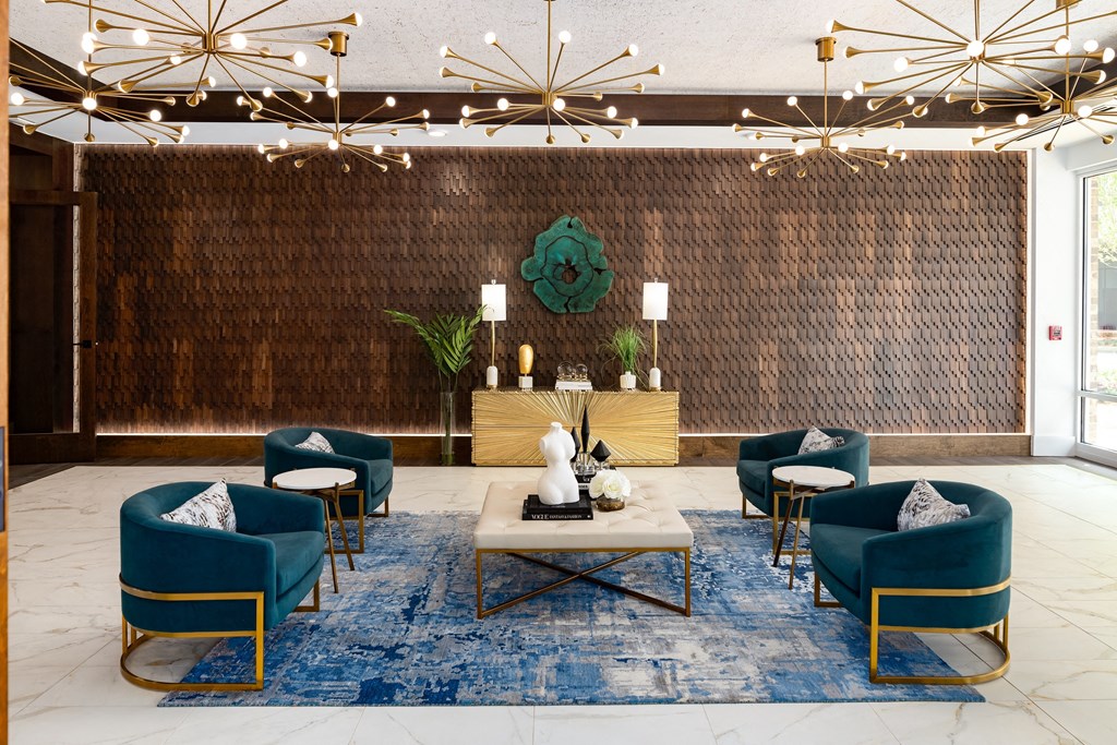 a lobby of a hotel with blue chairs and a blue rug