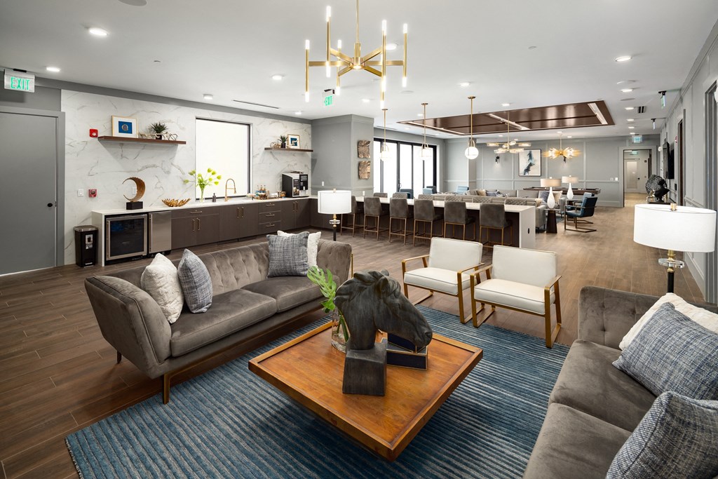 a clubhouse with couches and chairs and a table with a horse statue