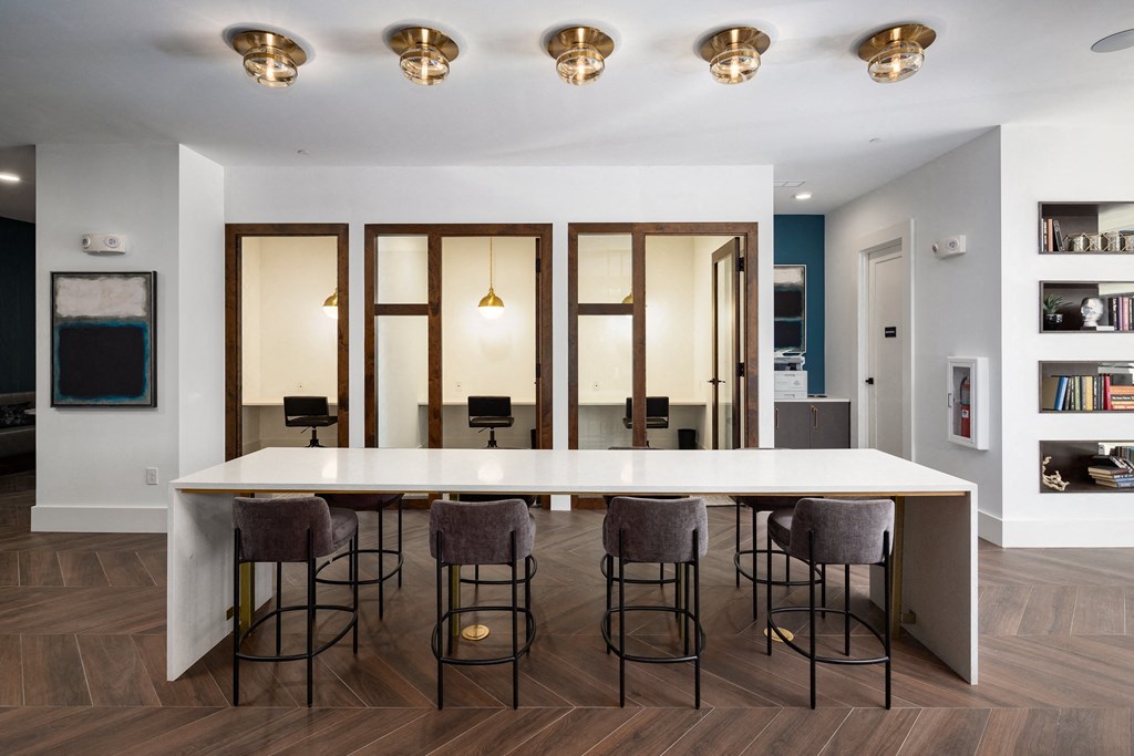 a dining room with a large white table and chairs