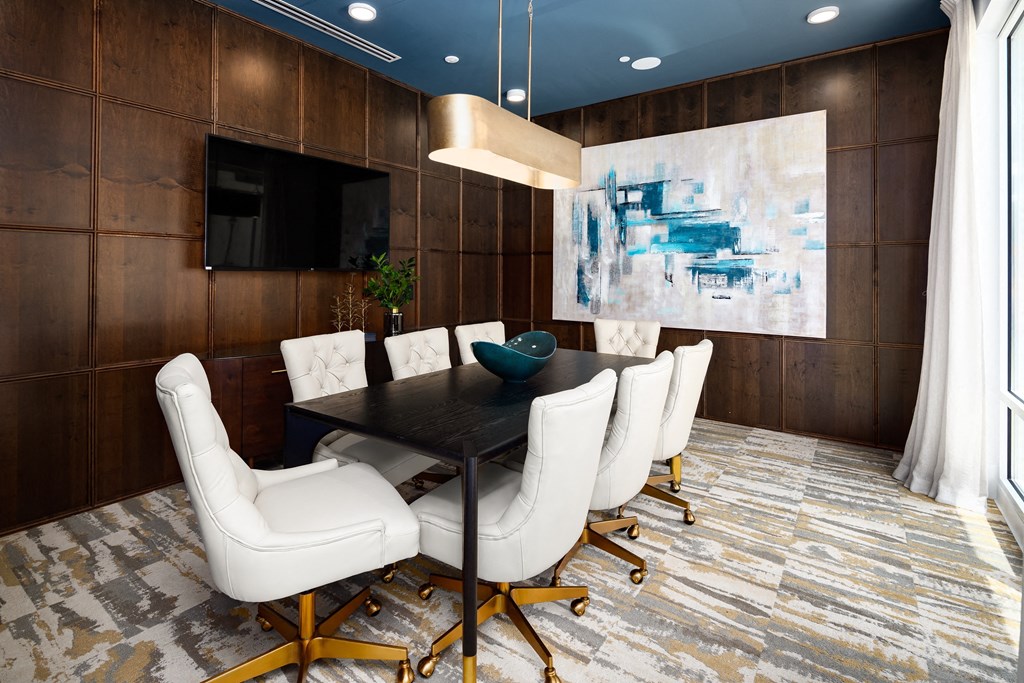 a dining room with a black table and white chairs