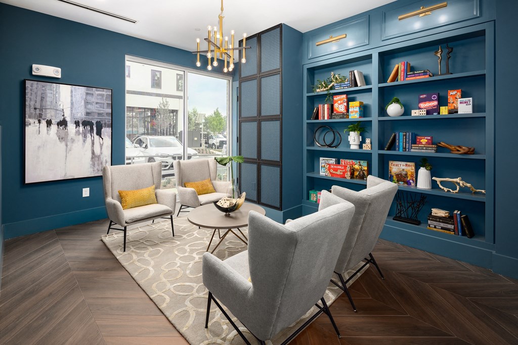 a living room with blue walls and chairs and a bookshelf