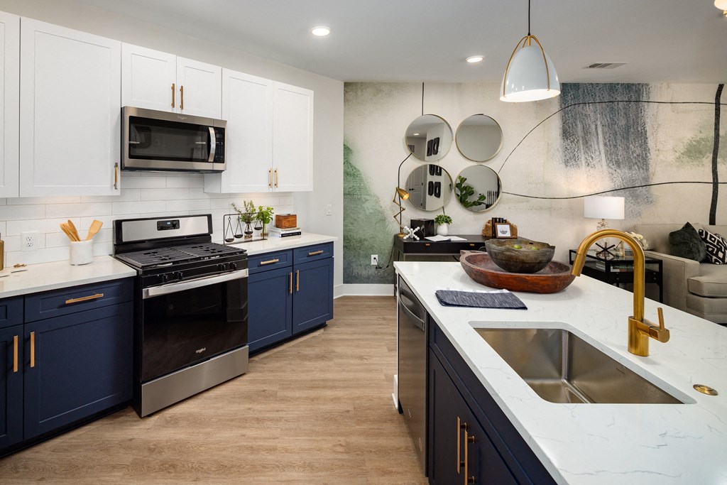 a kitchen with blue and white cabinets and stainless steel appliances