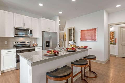 a kitchen with a large island with three stools