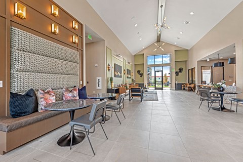a large lobby with tables and chairs and a chandelier