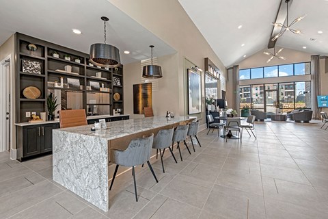 a large kitchen with a long island with chairs and a table