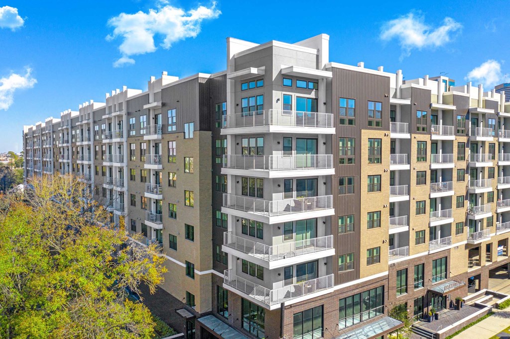 a large apartment building with many balconies and a blue sky