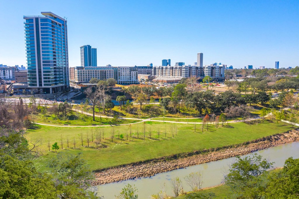 a park with a river and a city in the background
