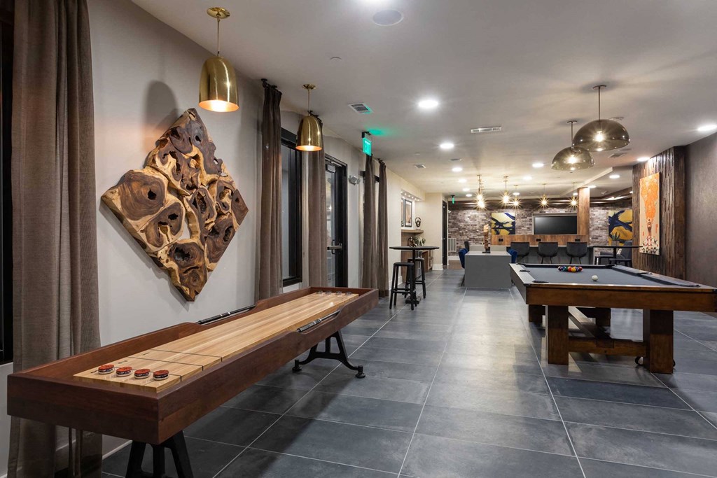 a game room with a shuffleboard table and a pool table