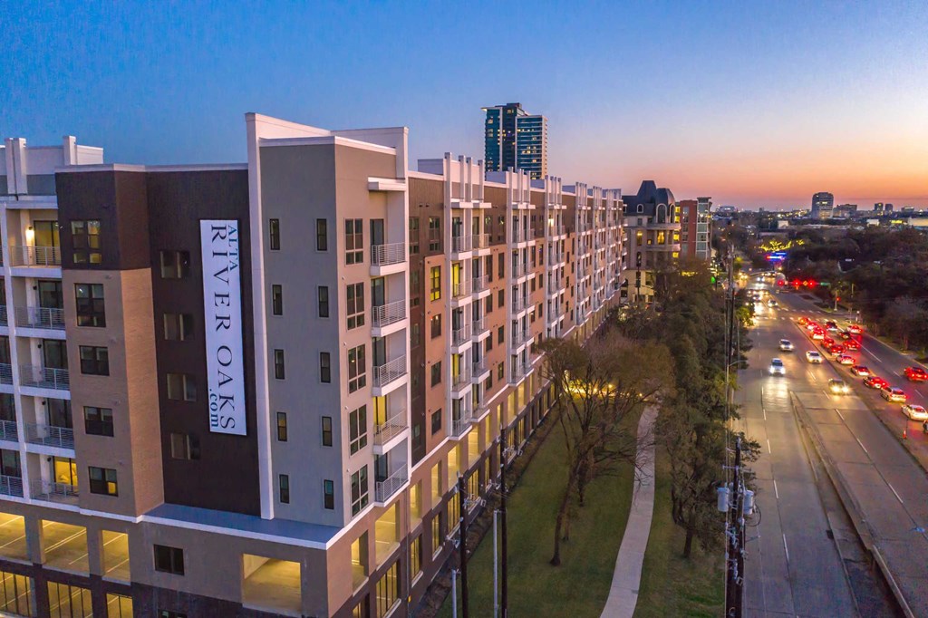 an aerial view of a building with a city at dusk