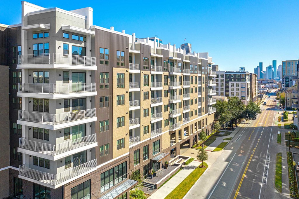 a building with many balconies and a city in the background