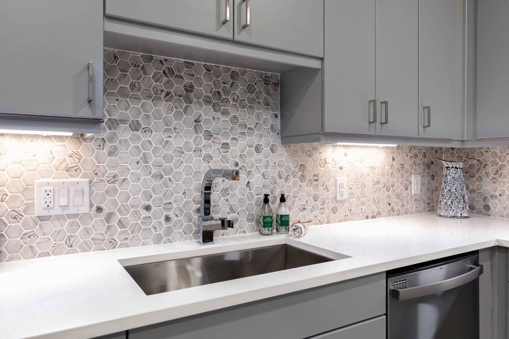 a kitchen with white counter top and a sink