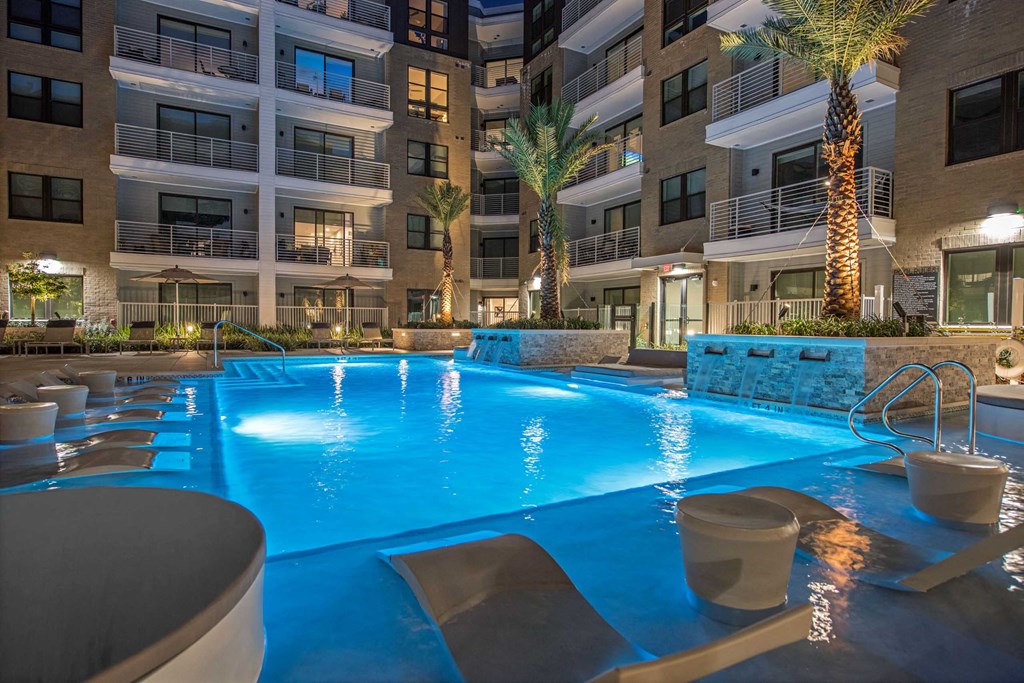 a large swimming pool with a building in the background