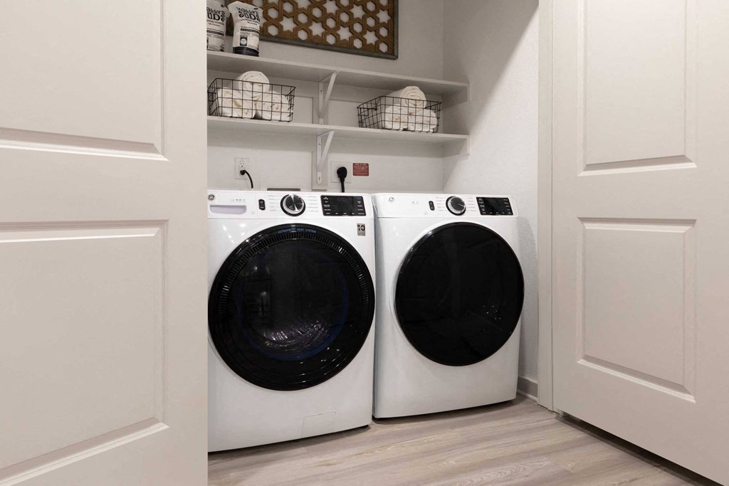 a washer and dryer in a laundry room with white cabinets