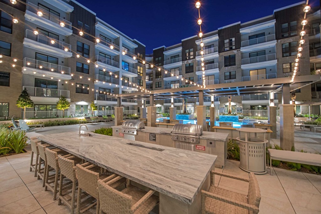 a communal patio with tables and chairs at night