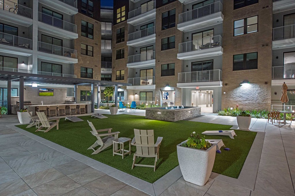 a rendering of a courtyard with chairs and tables in an apartment building