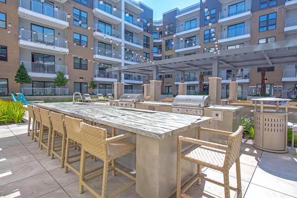 a patio with a table and chairs in front of an apartment building