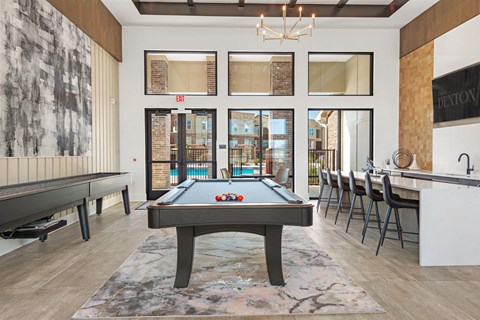 a pool table in a room with a bar and tables