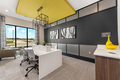 a conference room with a yellow ceiling and a desk with chairs