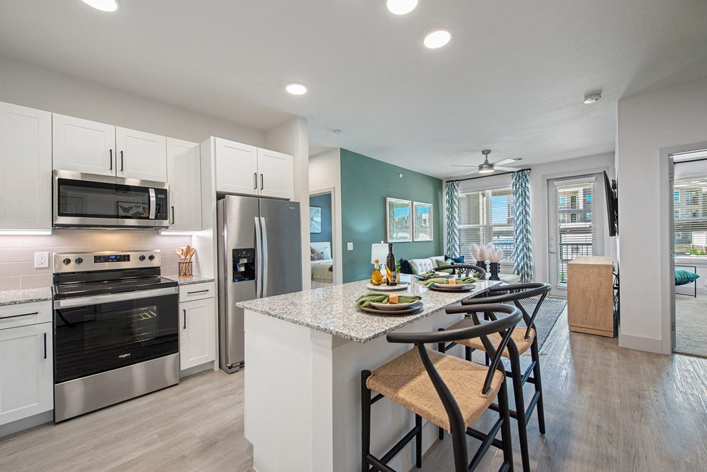 a kitchen with white cabinets and a table with stools