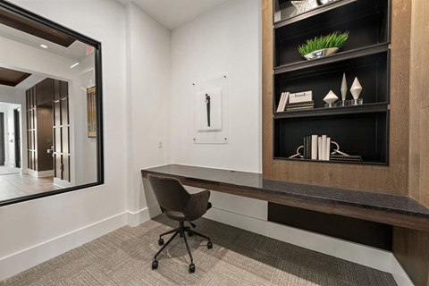 a desk in a room with a mirror and a chair