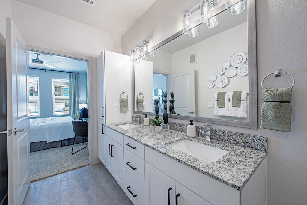 a bathroom with white cabinets and granite counter tops