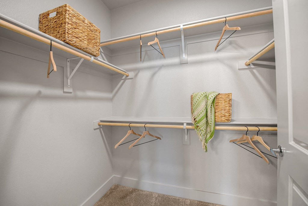 a walk in closet with hangers and a basket