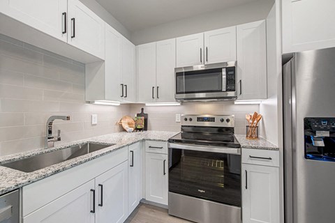 a kitchen with stainless steel appliances and white cabinets