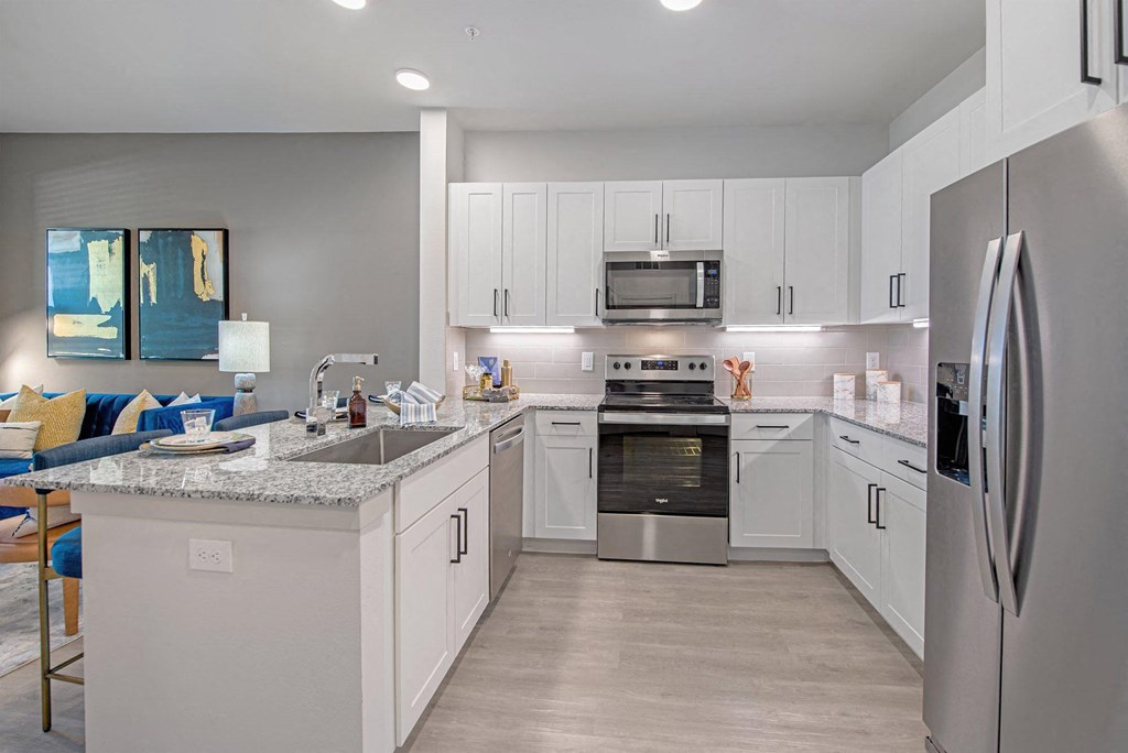 a kitchen with white cabinets and stainless steel appliances