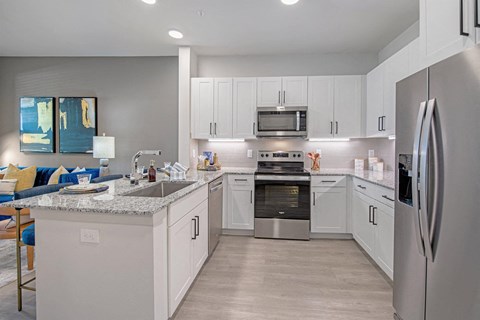 a kitchen with white cabinets and stainless steel appliances