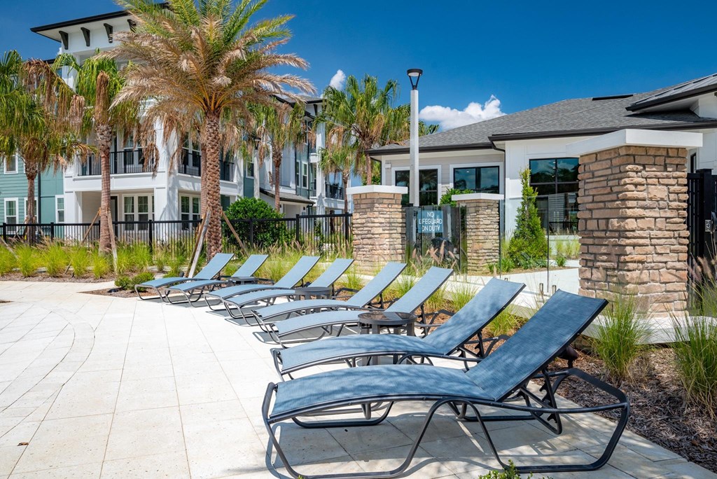 a row of chaise lounge chairs in front of a building