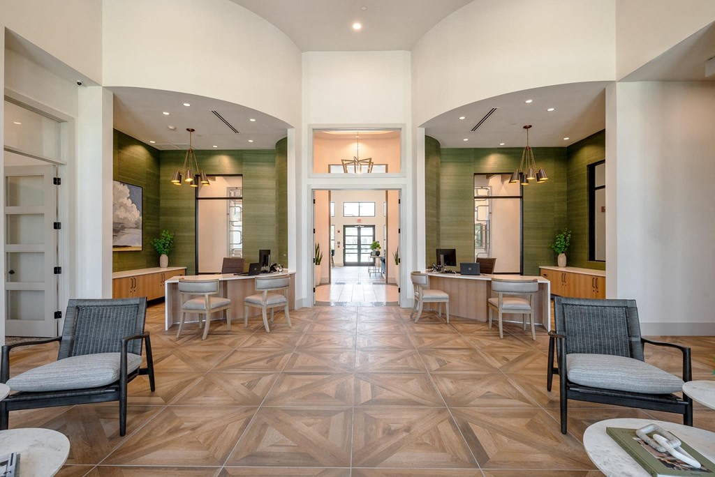 a large lobby with tables and chairs and a hallway