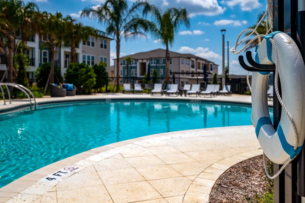 a swimming pool with chairs and a resort style pool