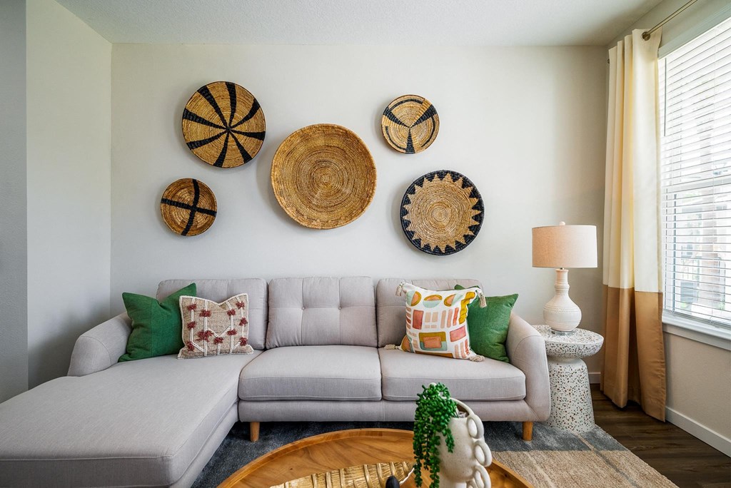 a living room with a couch and baskets on the wall