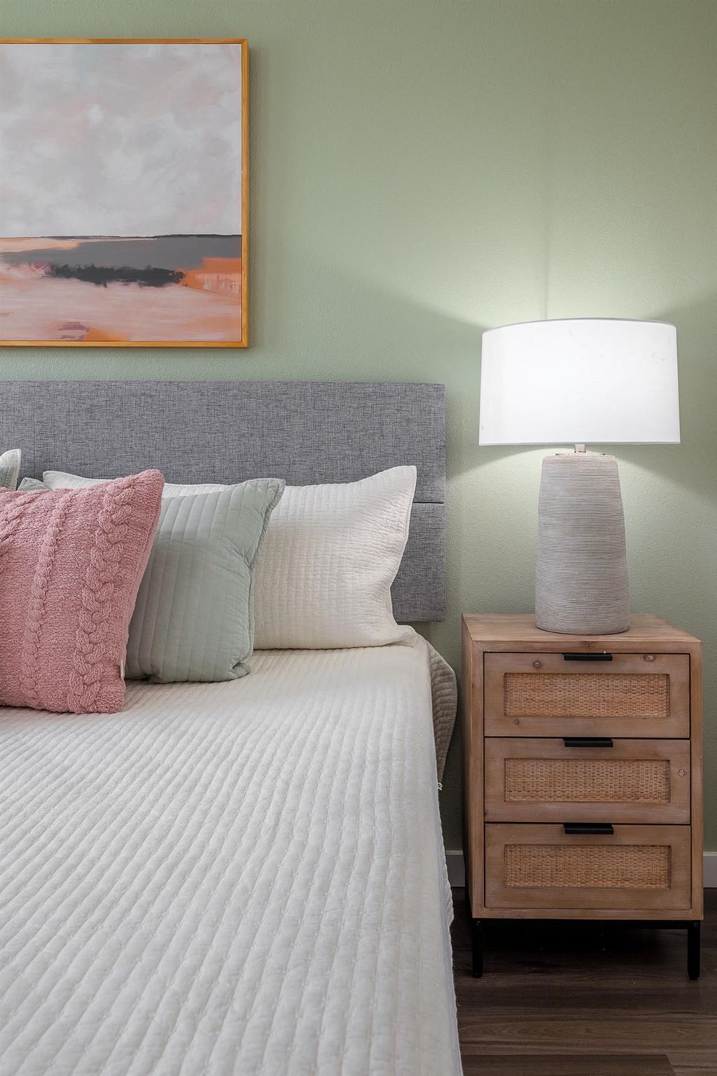 a bedroom with a bed and a lamp on a night stand