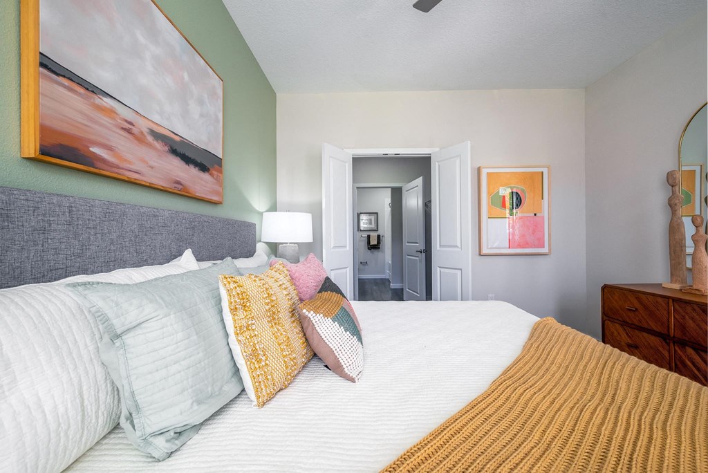 a bedroom with a large bed and a painting on the wall