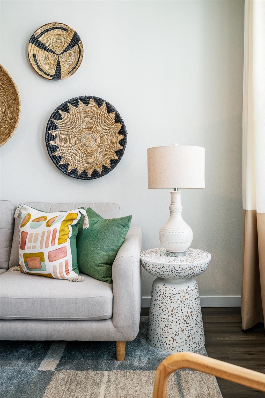 a living room with a couch and a lamp and some baskets on the wall