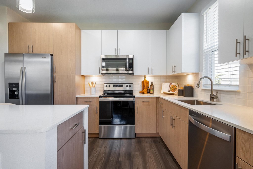 a kitchen with white cabinets and stainless steel appliances