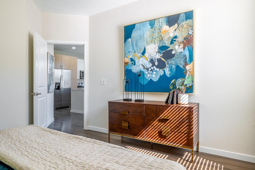 a bedroom with a bed and a painting on the wall