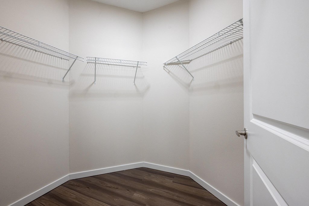 an empty closet with two hanging racks on the wall