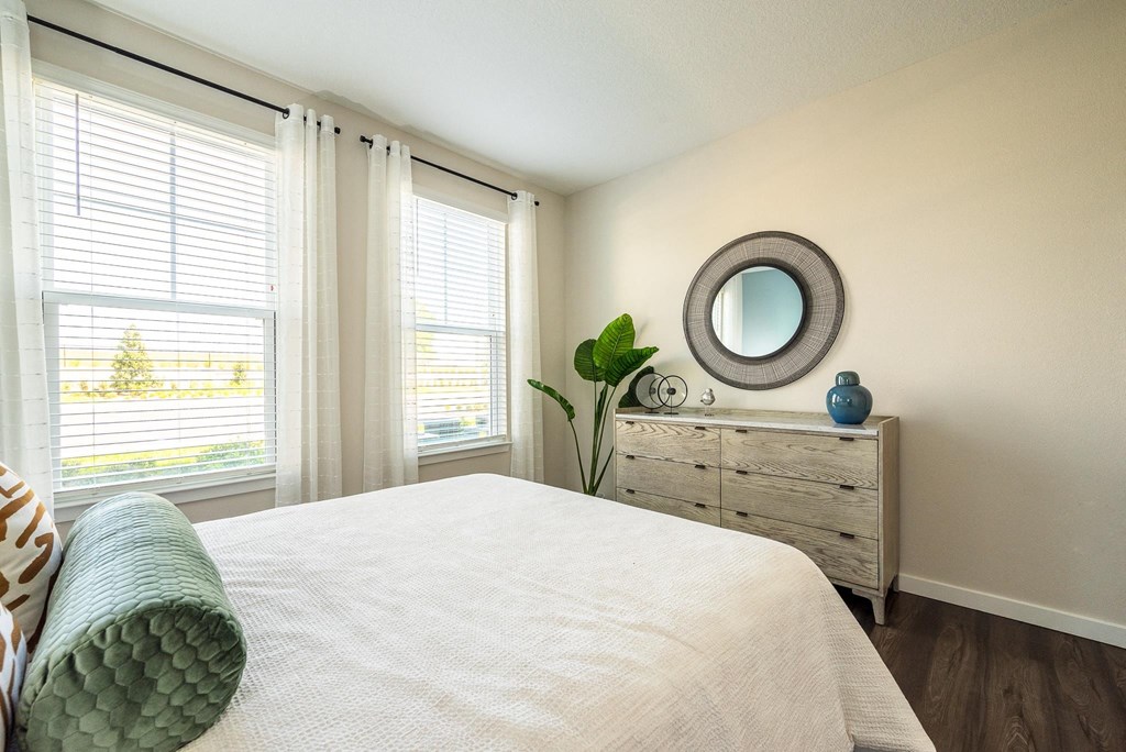 a bedroom with a bed and a dresser with a mirror