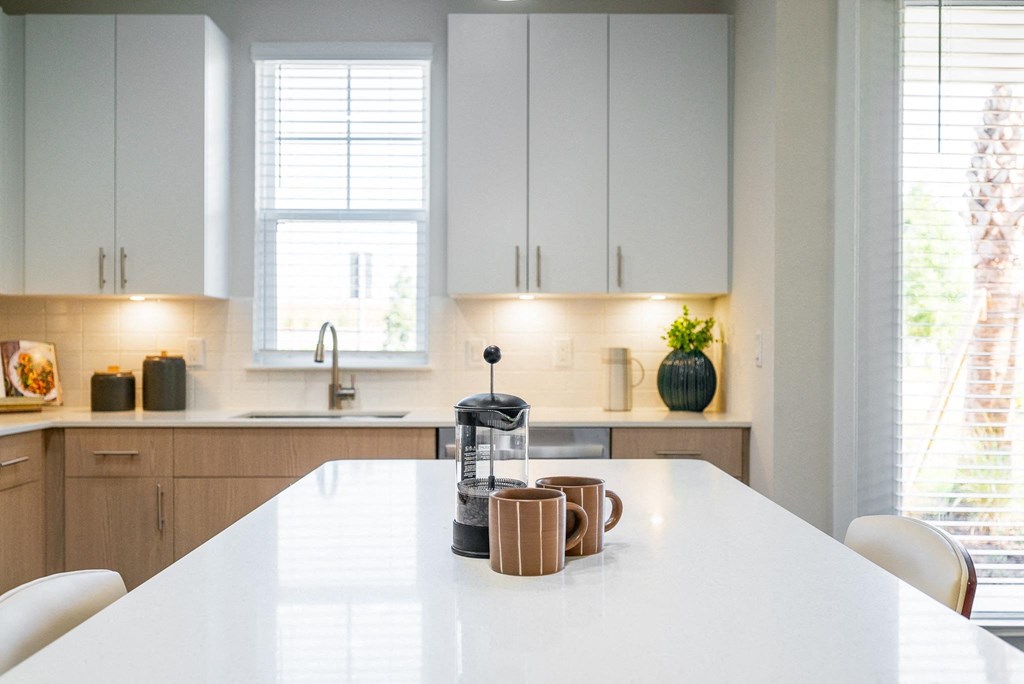 a kitchen counter with coffee cups and a coffee maker on it