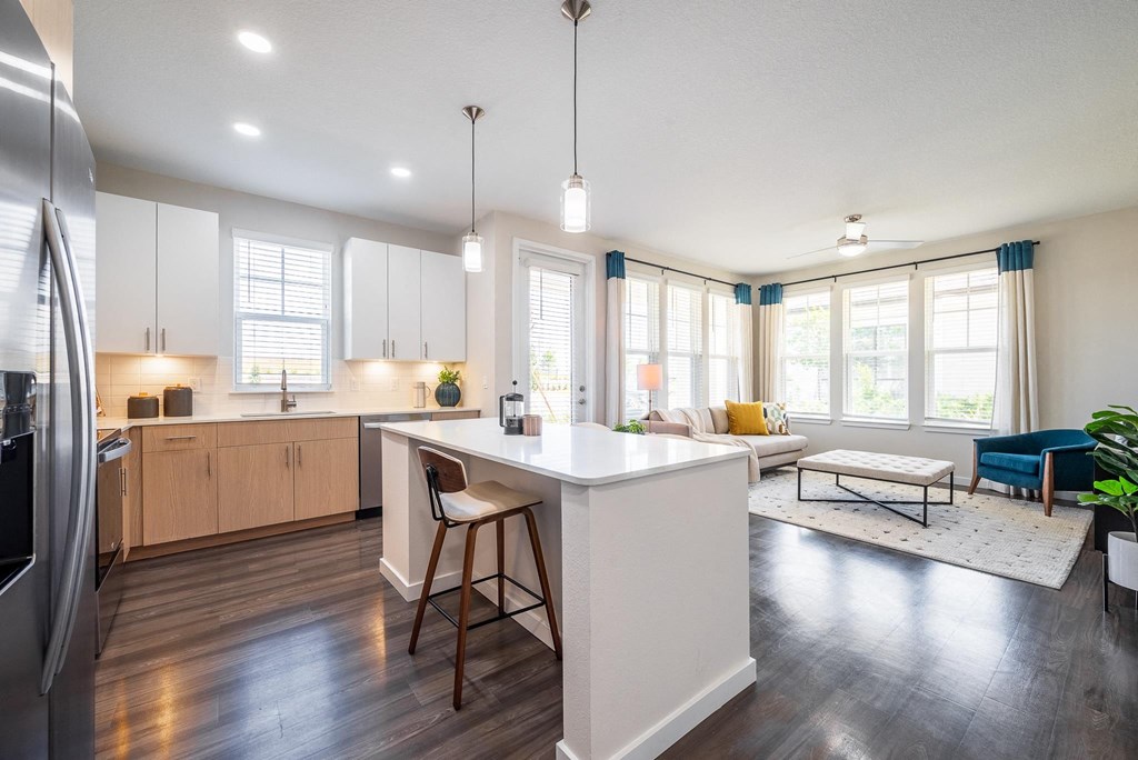 an open kitchen and living room with a white counter top