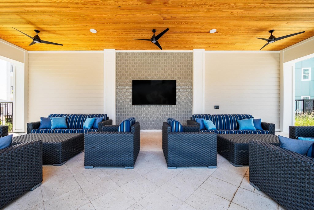 a patio with couches and chairs and a tv